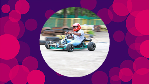 A purple background with pink circles on with Pravin's skeletal go kart in the middle of the canvas.