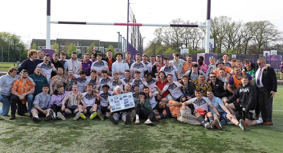 Rex is pictured on the grass in the centre of the image with players and members of Loughborough Students’ Rugby on the last game of the 22/23 season