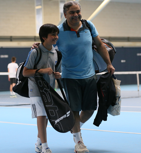 Adult and child on a tennis court