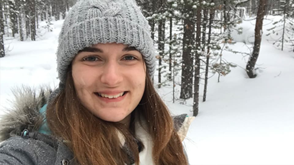 Chem Eng student, Beth Woof, in a forest with snow