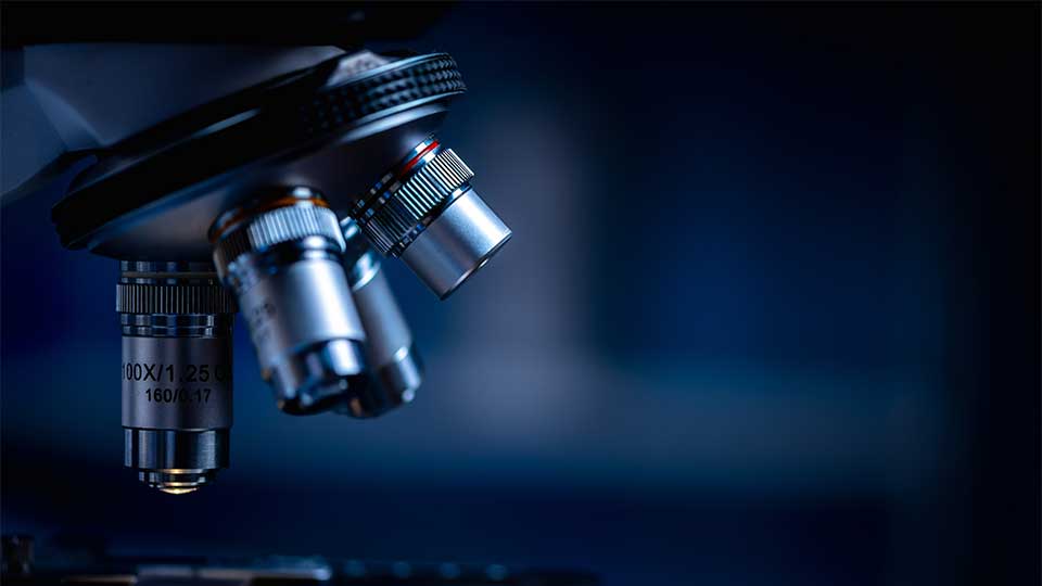Close-up of a microscope with a dark background.