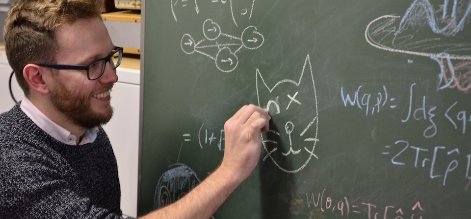 Russell Rundle writing on a chalk board
