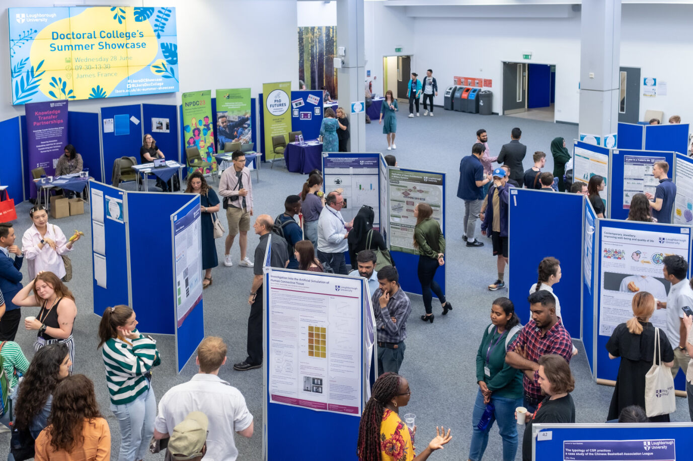 Doctoral researchers exhibiting their posters and networking.