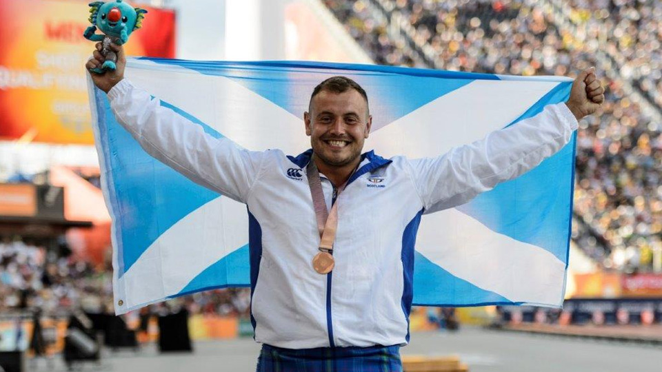 a man holding the Scottish flag