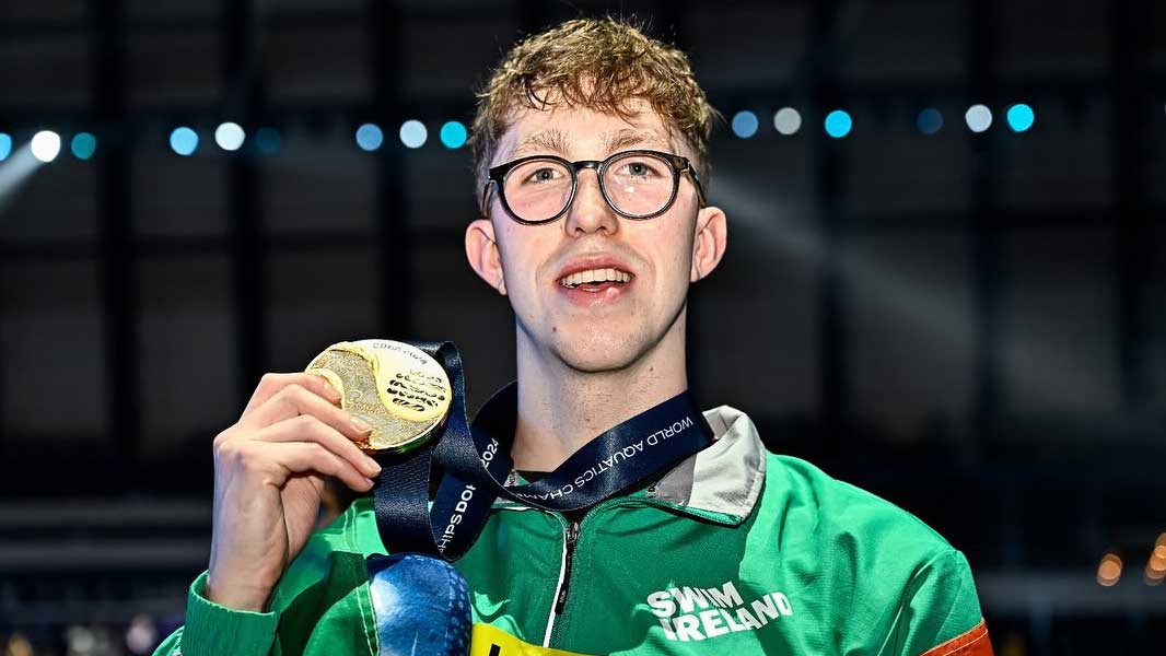 Current student, Daniel Wiffen, wearing and holding a gold medal as the Doha 2024 World Aquatics Championships