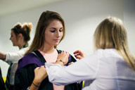 A graduand is helped into her graduation gown by staff from Ede and Ravenscroft.
