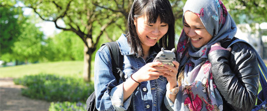 Two international students looking at a mobile phone