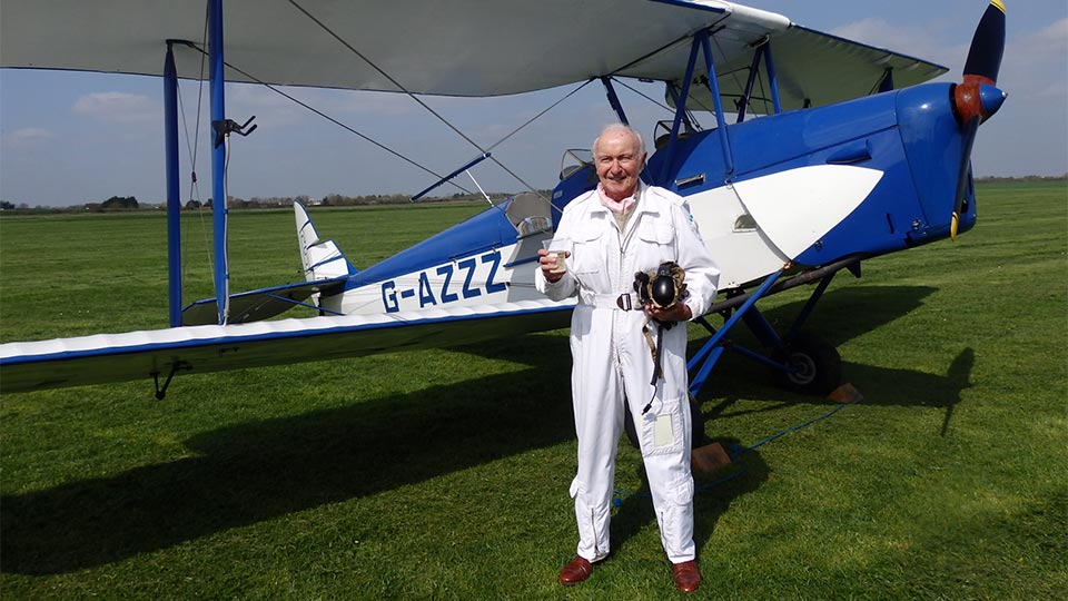Pictured is Captain Desmond Penrose with a DH82a Tiger Moth.