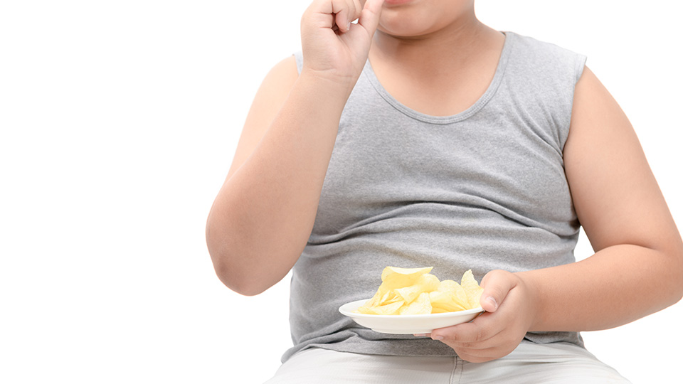 Pictured is a child eating crisps. 