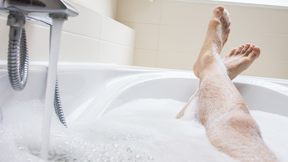 Pictured is a man's legs in a bath. 