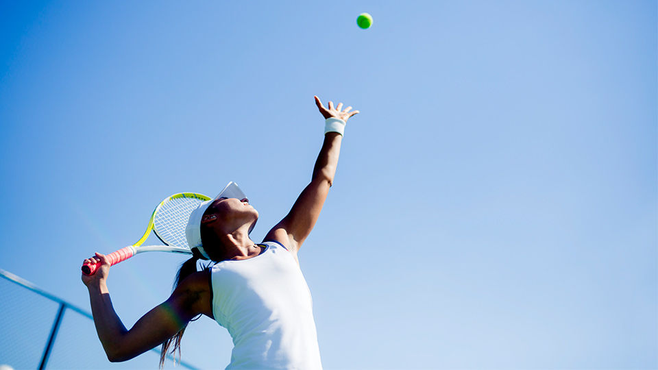 A woman hitting a tennis ball. 