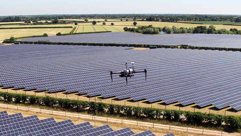 A drone flying over a solar panel farm. Image courtesy of Above. 

