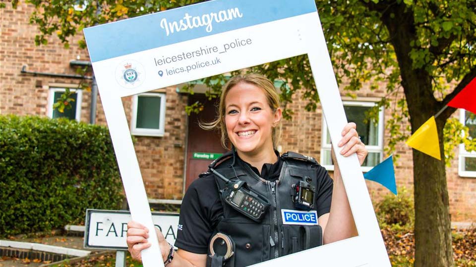 PC Charlotte Dickens with Instagram sign outside university hall of residence