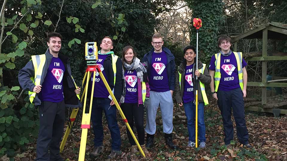 Engineering students helping outdoors with scouts building project