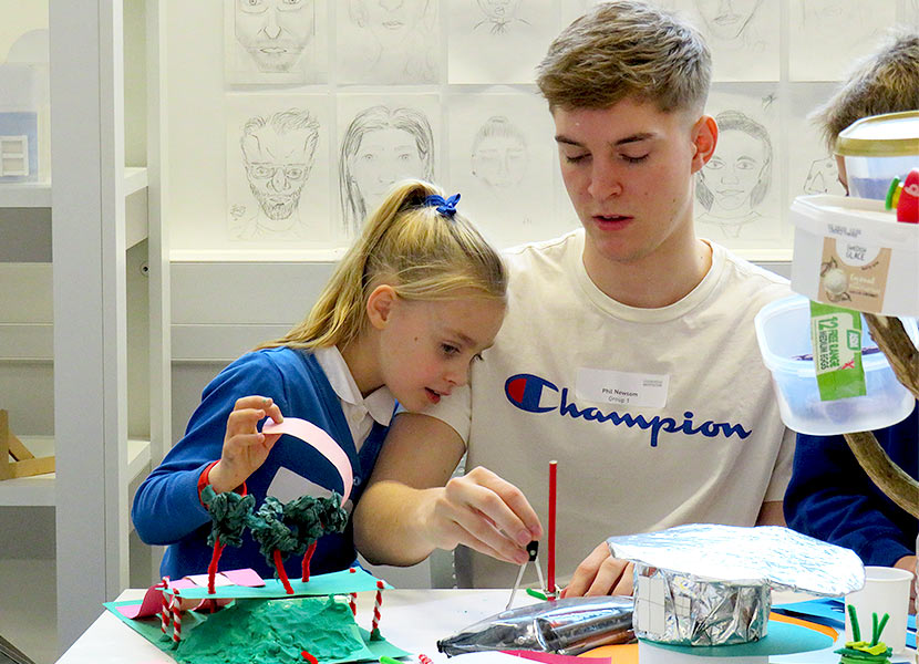 Loughborough University student helps St Bart's pupil with their classroom design. 