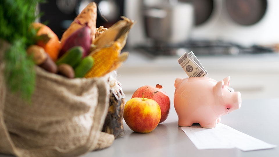 Photo of healthy food and a piggy bank with money