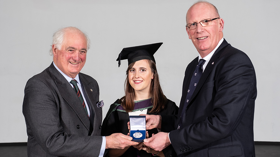 photo of female student being awarded with University prize by Professor Robert Allison