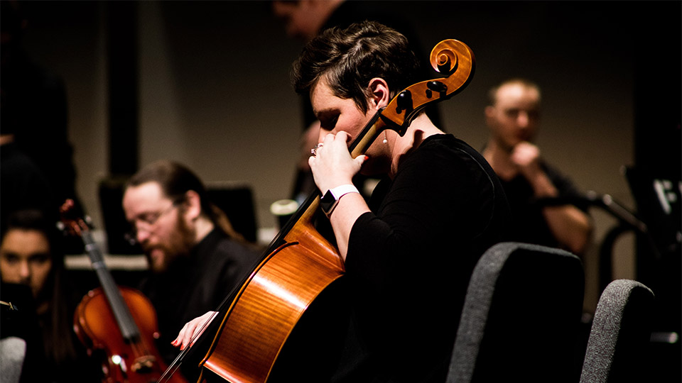 Photo of a man playing the cello at a concert