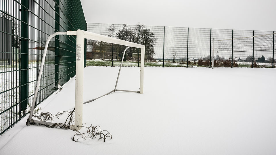 A football goal on a snowy outdoor football pitch