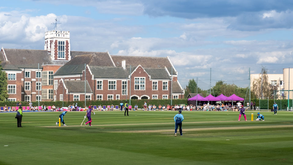 A cricket match underway on the University campus - the Hazlerigg building is in the background
