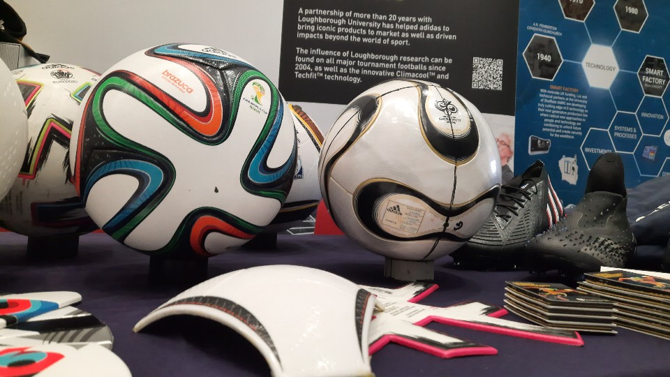 A selection of adidas footballs and boots laid out on a table