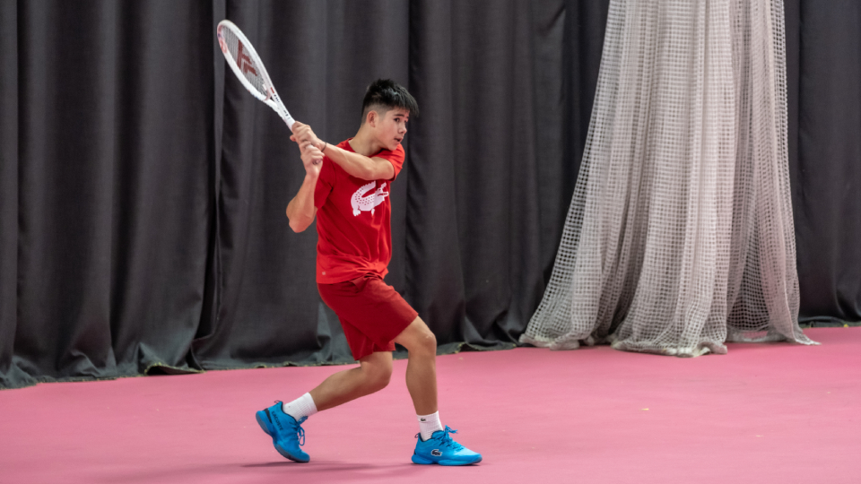 tennis player Ben Gusic-Wan striking the ball