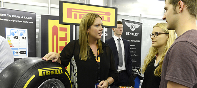 Pirelli rep speaking to two students.