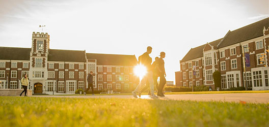 Students walking around the Hazlerigg Rutland area in sunlight