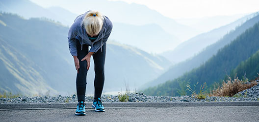 photo of a woman experiencing knee discomfort during exercise