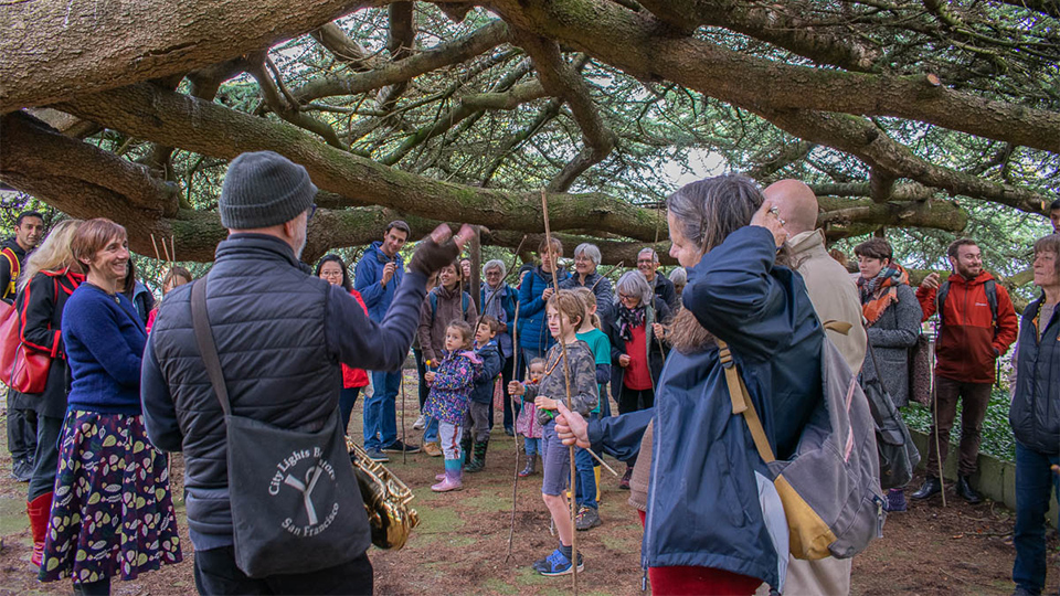 Photo of guests gathered by a tree outside during the Fruit Routes Harvest event