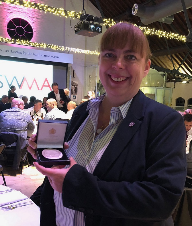 Photo of Dr Higginson holding her Stokowiec Medal 