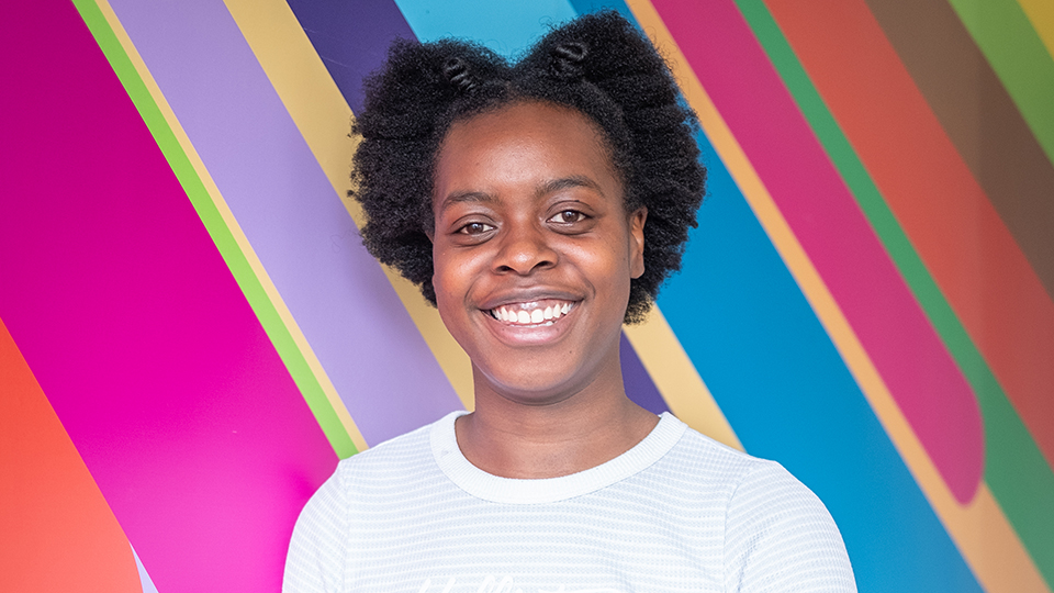 Valerie standing in front of a colourful wall.