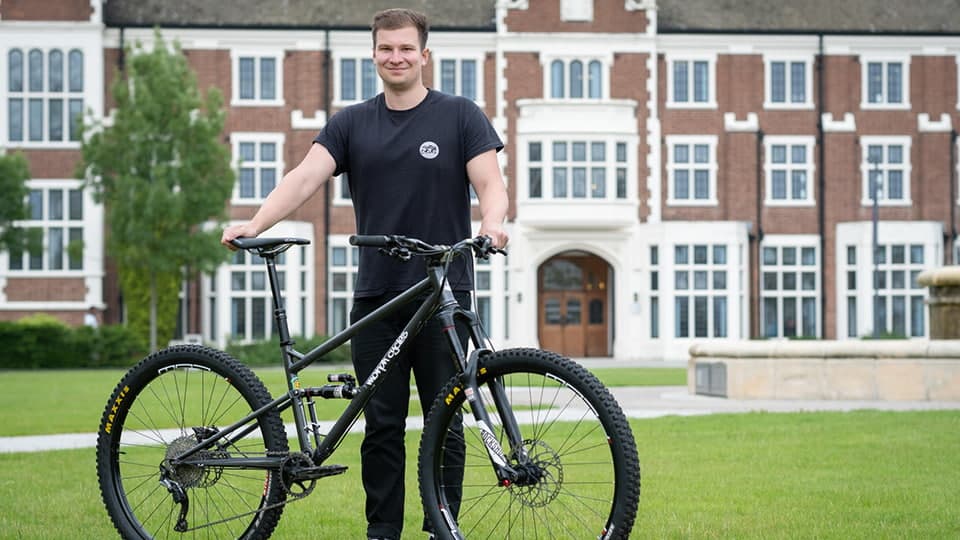 Sport Technology student stood by their bike.