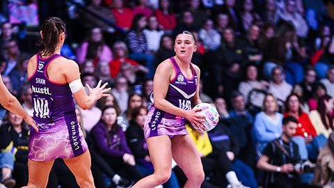 millie van nierop holding the netball on court looking for a pass