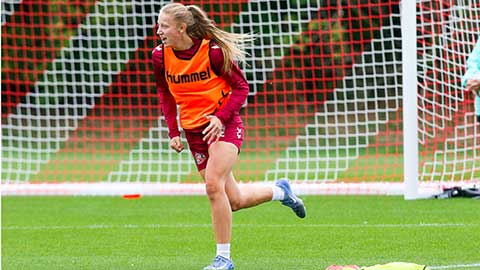 Ella West running on a football pitch
