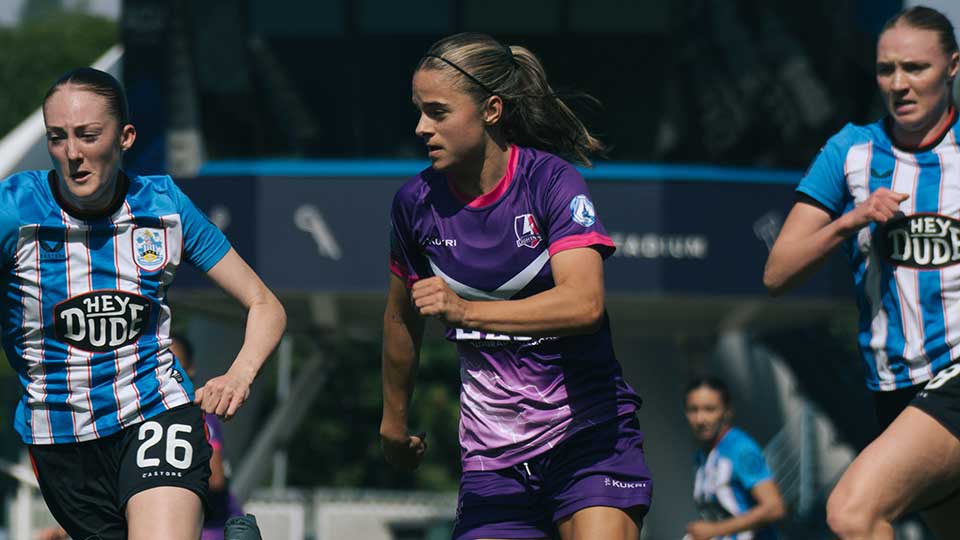 A lightning football player and Huddersfield players on pitch mid game