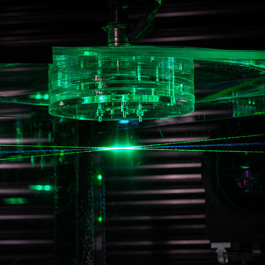 Three laser beams converging in a central point with a sensor array above them