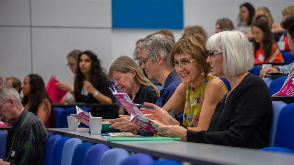 Conference attendees sitting in a lecture theatre on campus