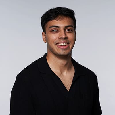 A headshot of Abhi Ghavalkar. He is wearing a black shirt and smiling at the camera.