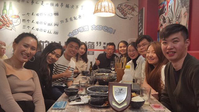 Group of Chinese alumni sitting around a table at a restaurant 