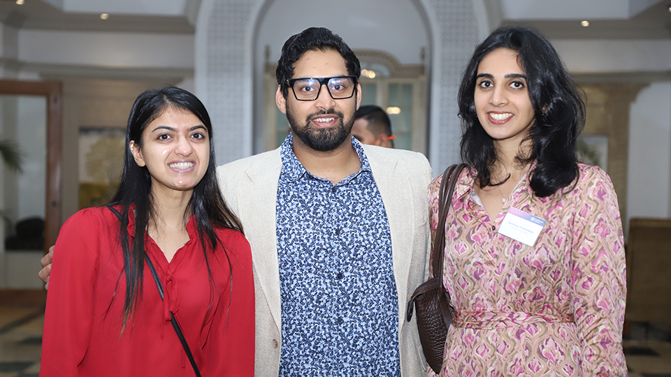 Three alumni stand together at the event in Mumbai
