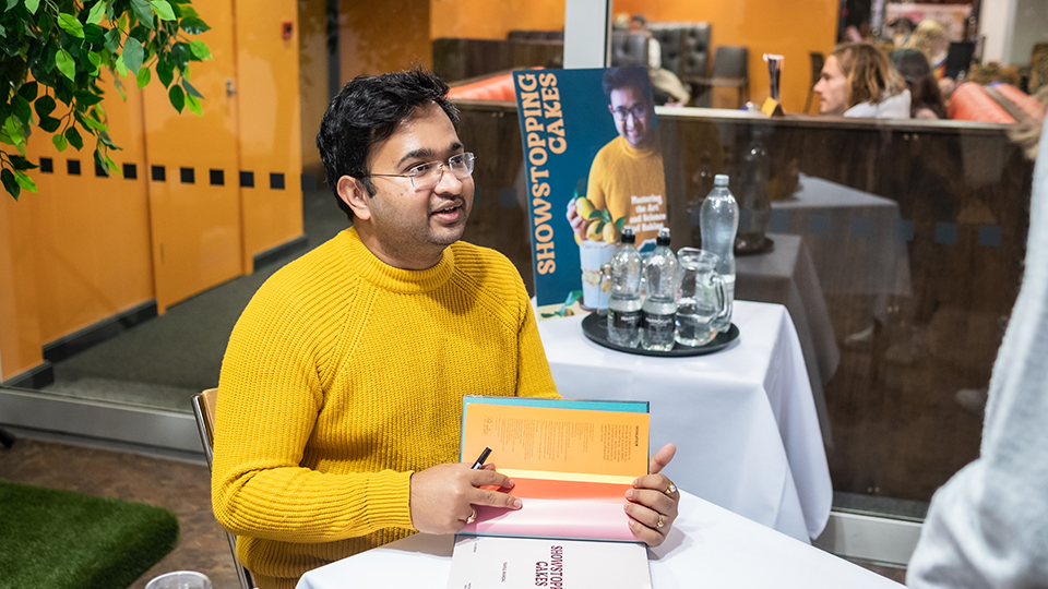 Rahul Mandal seated signing a book