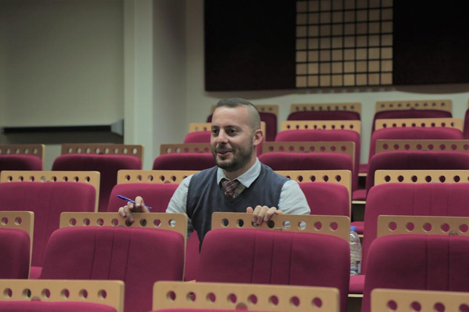 Gaby sitting in the empty seating of a theatre.