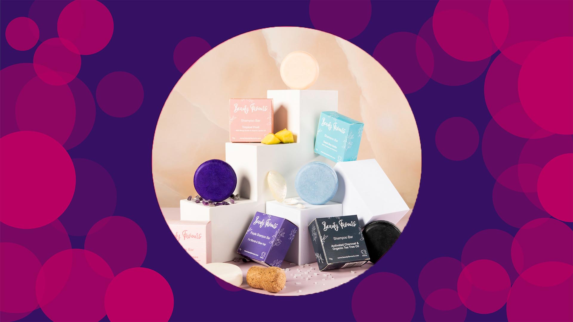Purple background with pink circles, with an image in the middle of a set up of beauty favours different shampoo bars