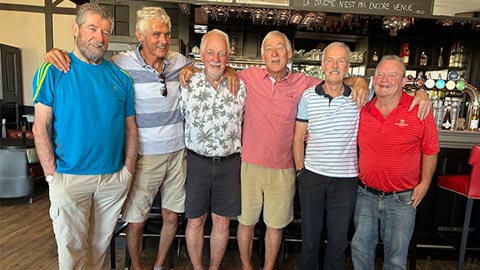Group of six alumni standing smiling at the camera