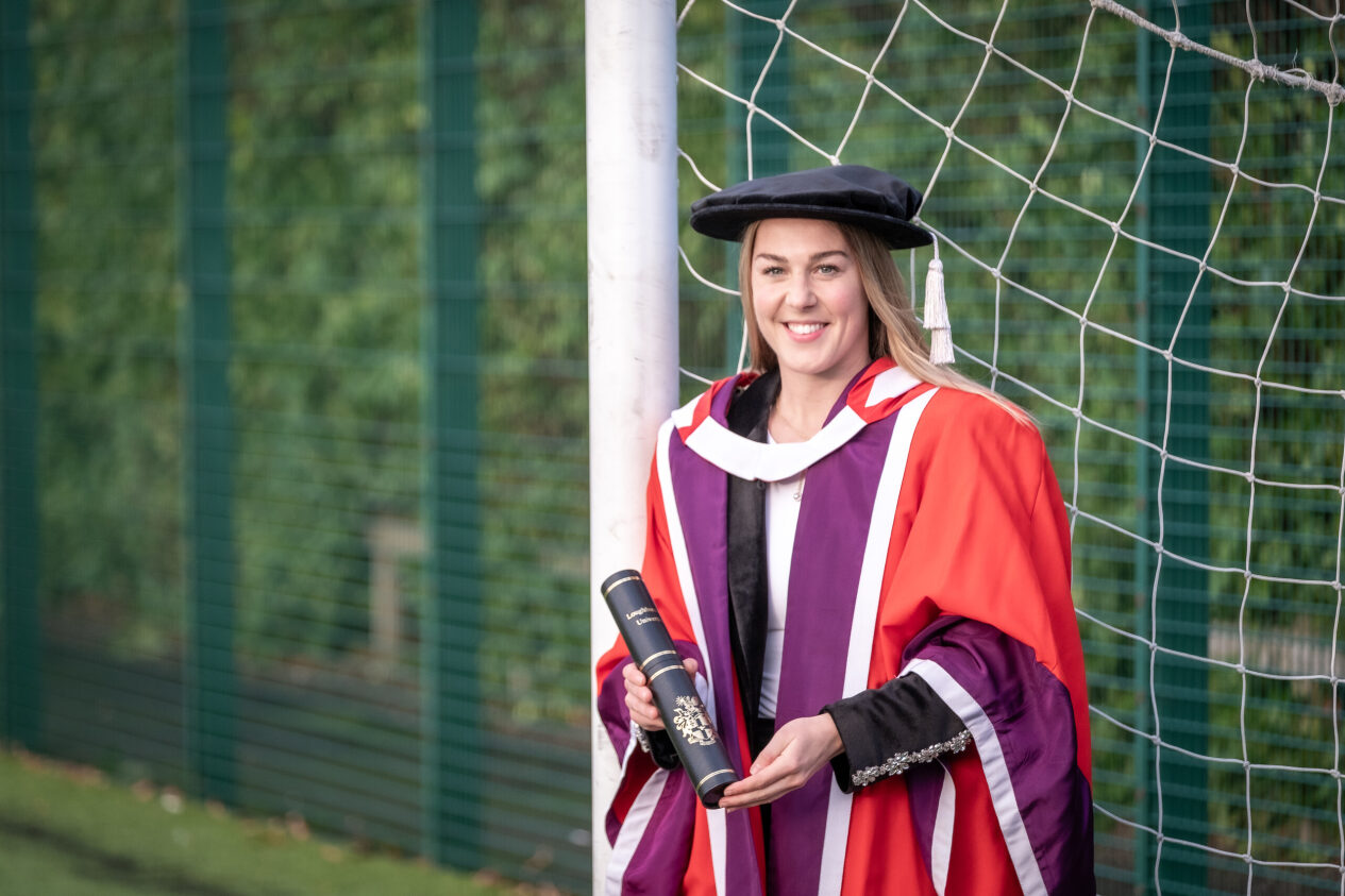 Mary Earps standing on football field holding graduation certificate