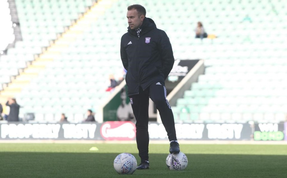 Charlie Baxter at a football stadium, standing on the pitch with two footballs at his feet