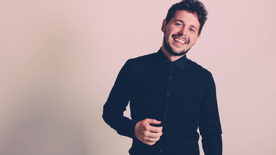 Professional photo of Tom Stevenson, who is wearing a navy, button-up shirt and smiling to the camera.