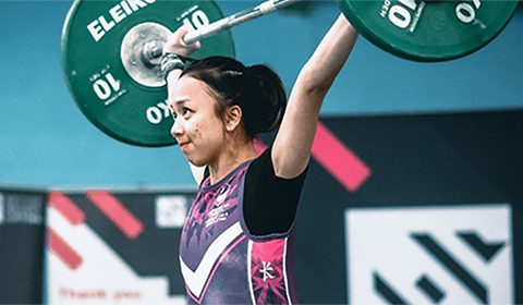 Syuhaidah Ahman pictured wearing a Loughborough Sport vest top, lifting weights