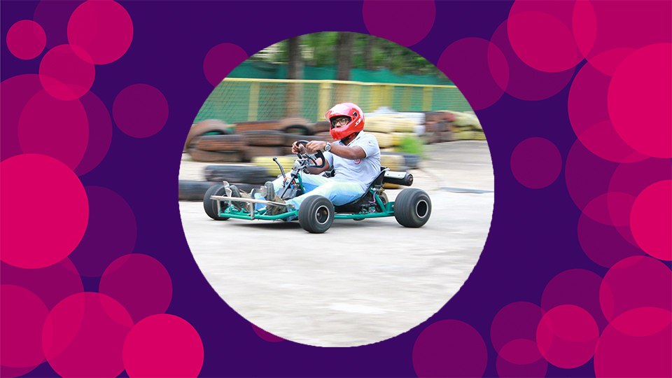 A purple background with pink circles on with Pravin's skeletal go kart in the middle of the canvas.